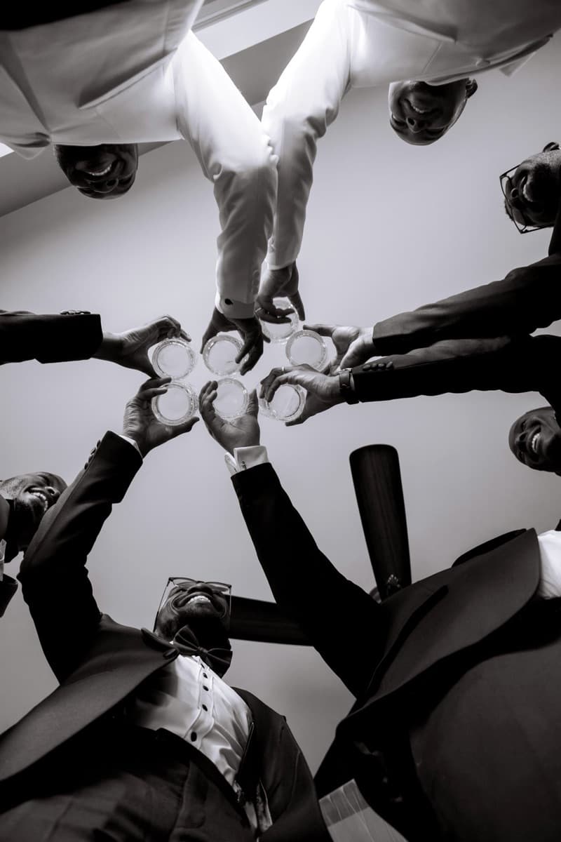 Groomsmen raising glasses in a black & white toast