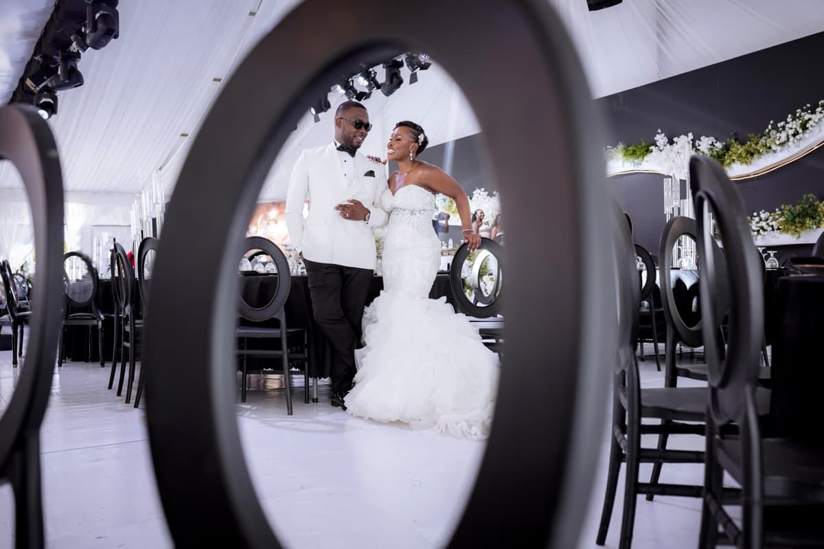 Couple framed through elegant oval-back reception chairs